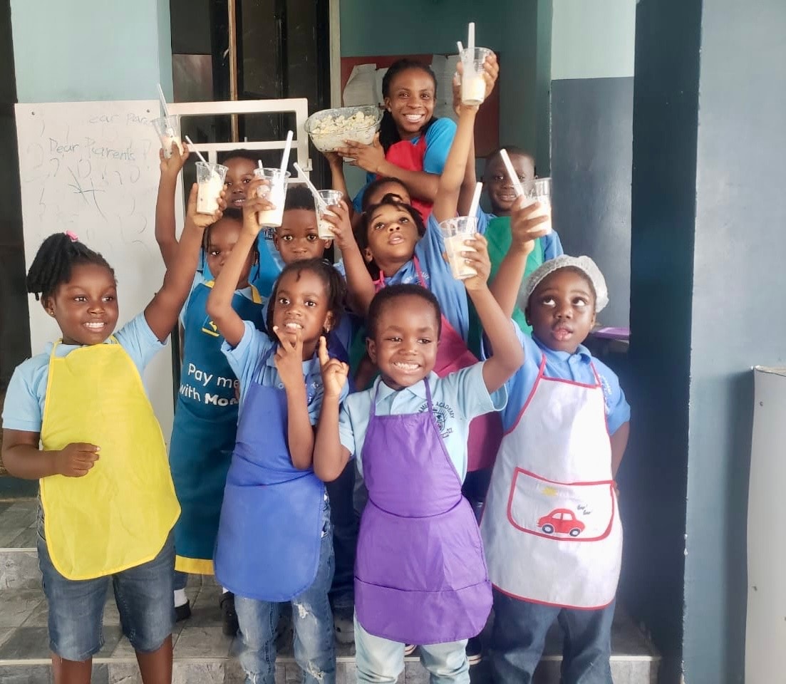 Students in aprons holding up their smoothie cups