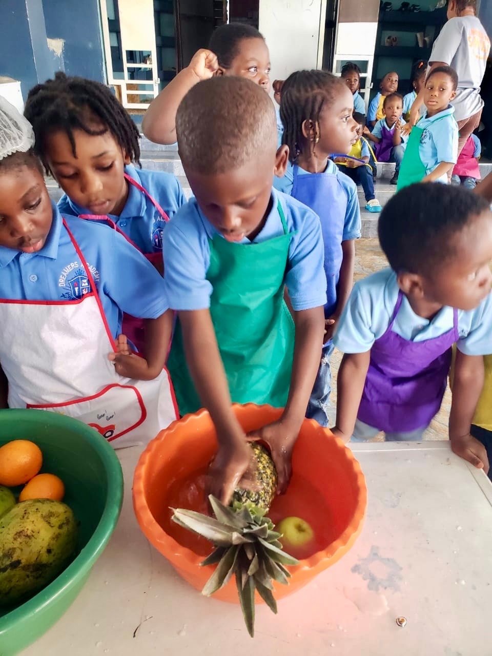 Students washing fruit together at the preparation table